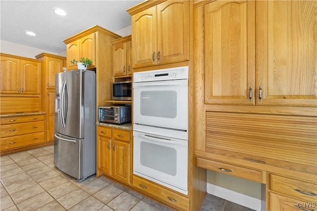 kitchen with appliances with stainless steel finishes and light tile patterned flooring