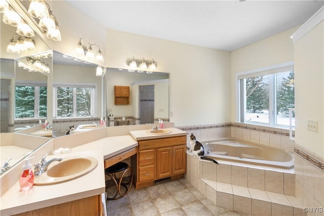 bathroom with tiled bath, tile patterned flooring, a wealth of natural light, and vanity