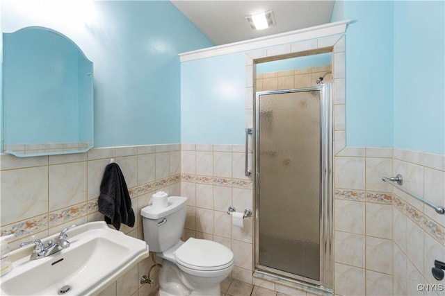 bathroom featuring sink, tile walls, toilet, and a shower with shower door