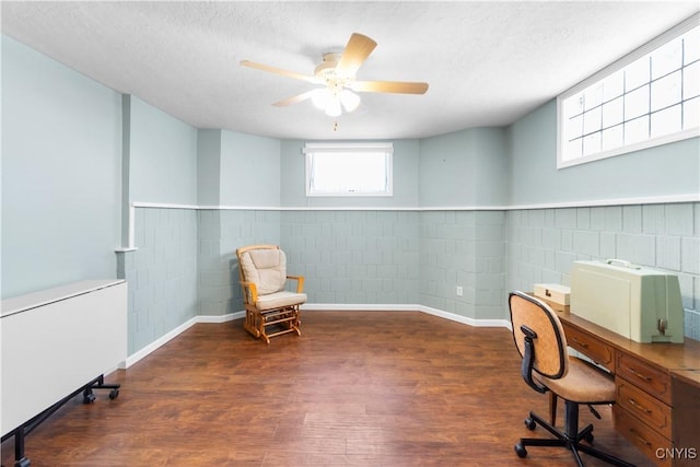 office space featuring ceiling fan, dark wood-type flooring, and a textured ceiling