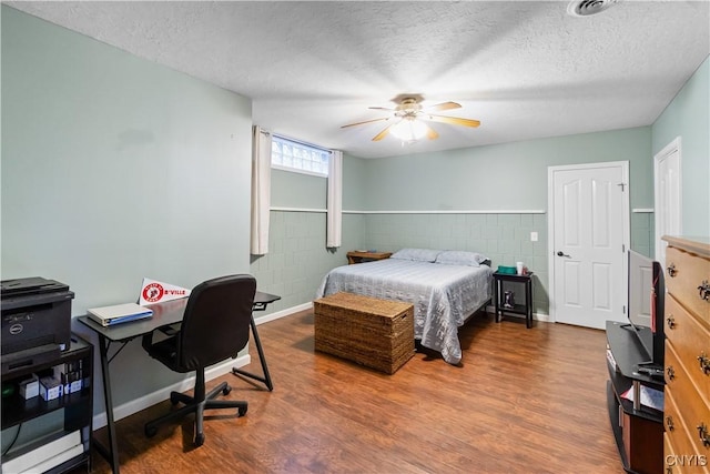 bedroom featuring a textured ceiling, ceiling fan, and dark hardwood / wood-style floors