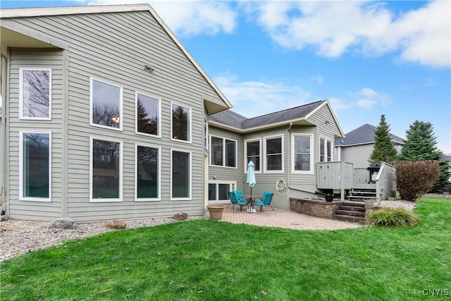 rear view of property featuring a patio, a deck, and a yard