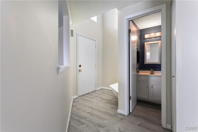 hallway featuring sink and light wood-type flooring