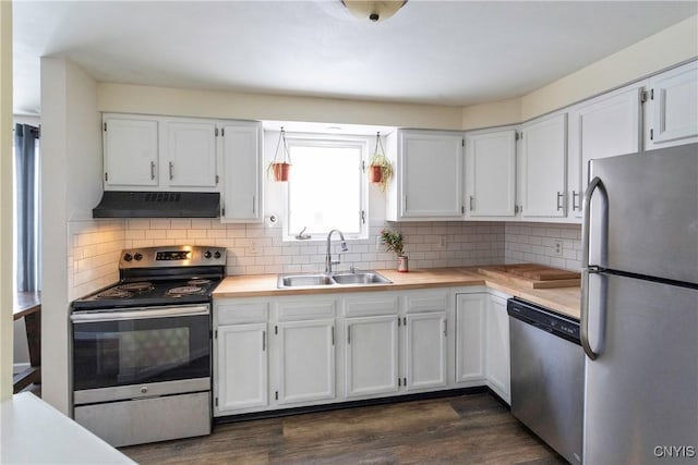 kitchen featuring white cabinets, stainless steel appliances, dark hardwood / wood-style flooring, sink, and backsplash