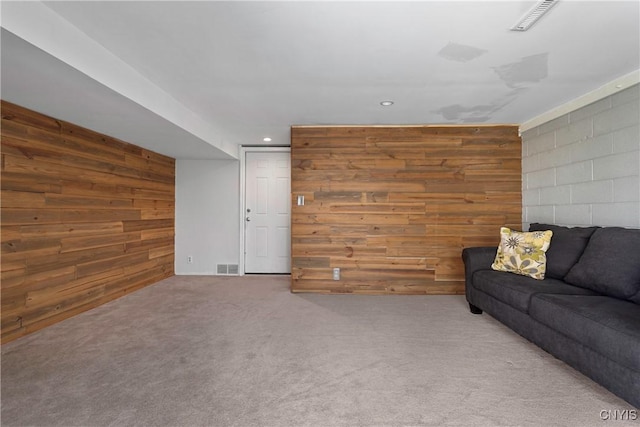 unfurnished living room with wooden walls and carpet