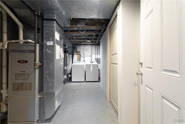 basement featuring washer and dryer, water heater, and heating unit