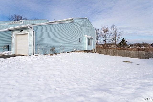 snow covered property with a garage