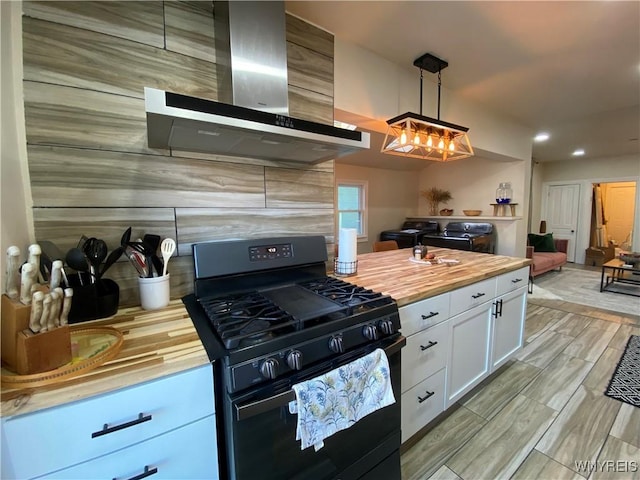 kitchen with black gas range, white cabinets, wooden counters, hanging light fixtures, and extractor fan