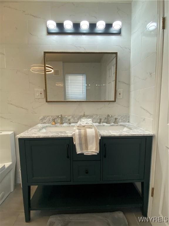 bathroom featuring vanity and tile walls