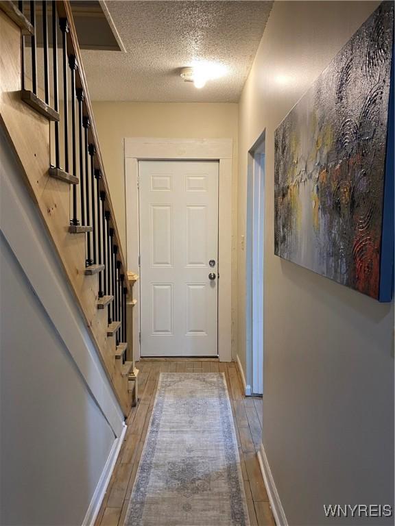 doorway to outside featuring a textured ceiling