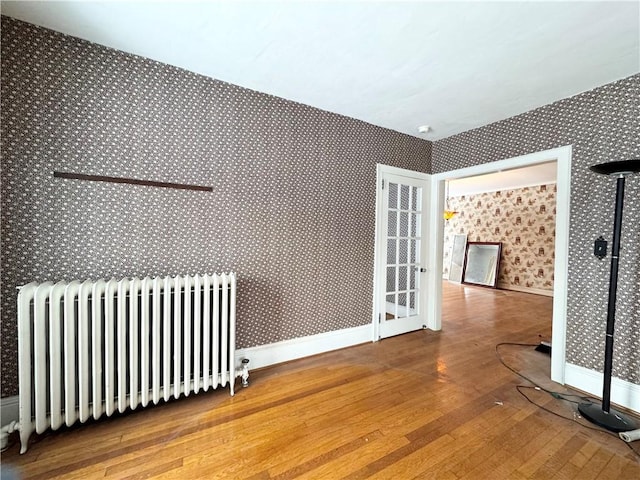 interior space with radiator heating unit and hardwood / wood-style flooring