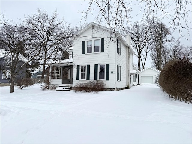 view of front of home with a garage and an outdoor structure