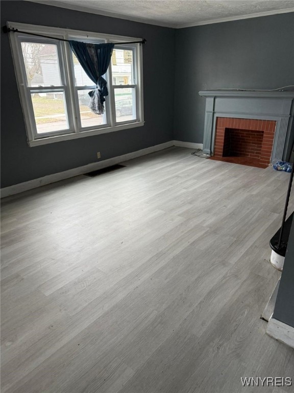 unfurnished living room featuring a textured ceiling, light hardwood / wood-style floors, and a fireplace