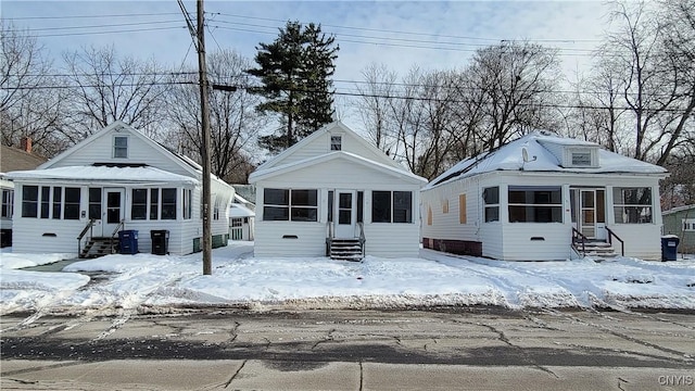 view of front of house with a sunroom and central AC unit