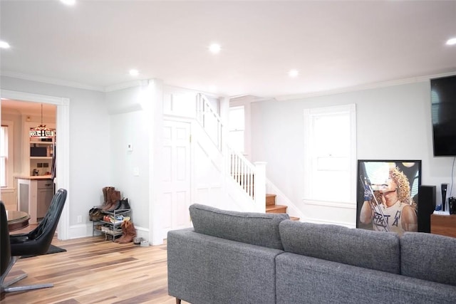 living room featuring light wood-type flooring and ornamental molding