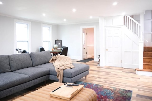 living room featuring light wood-type flooring and crown molding