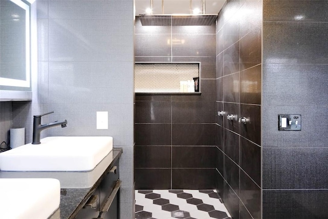 bathroom featuring tile walls, walk in shower, and vanity