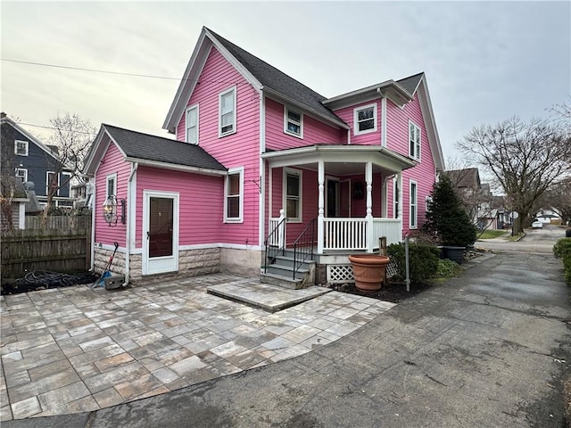 back of property featuring a porch and a patio