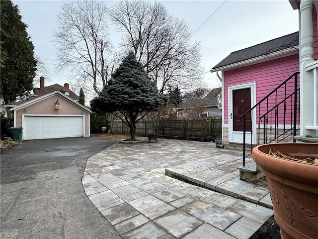 view of patio / terrace with a garage and an outbuilding