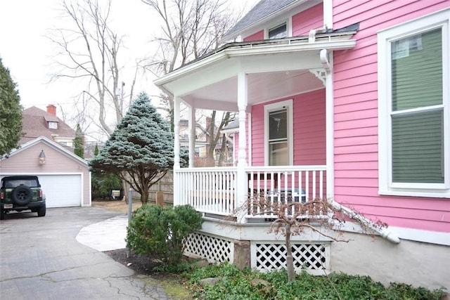 view of home's exterior with a porch, a garage, and an outdoor structure