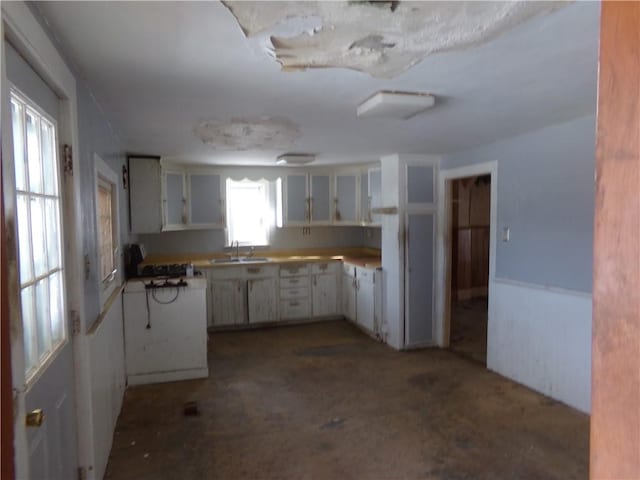 kitchen with stove, sink, and white cabinets