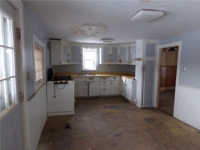 kitchen featuring white cabinetry, sink, and stove