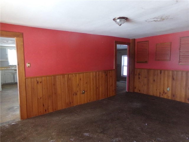 unfurnished room with wood walls