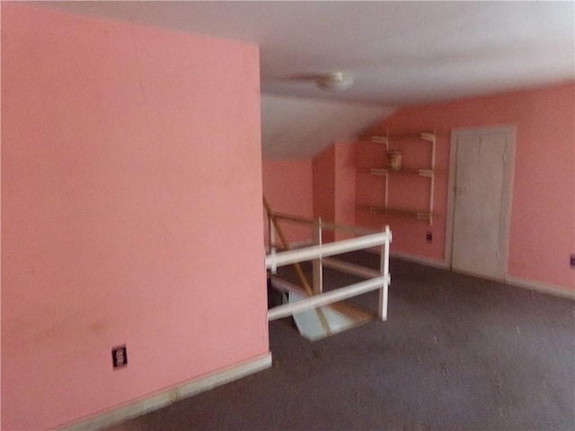 interior space with lofted ceiling and dark carpet