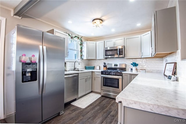 kitchen featuring sink, decorative backsplash, dark hardwood / wood-style floors, gray cabinetry, and appliances with stainless steel finishes