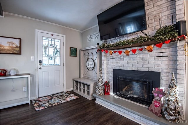 entrance foyer featuring dark wood-type flooring, crown molding, and a fireplace