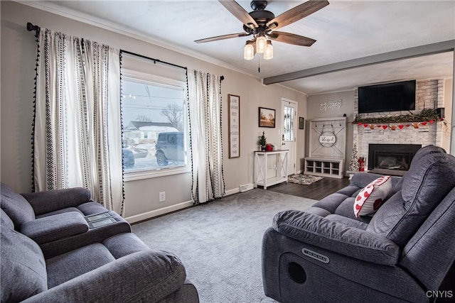 carpeted living room with ceiling fan, a stone fireplace, crown molding, and plenty of natural light