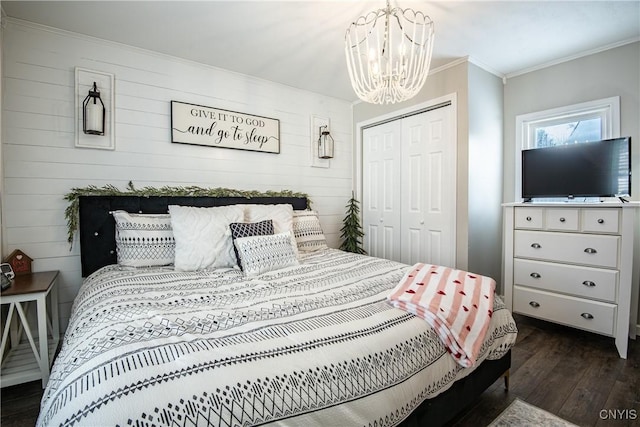 bedroom featuring a closet, a notable chandelier, crown molding, and dark hardwood / wood-style flooring