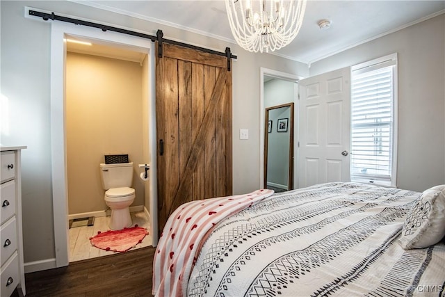 bedroom featuring ensuite bathroom, a barn door, a chandelier, crown molding, and dark wood-type flooring