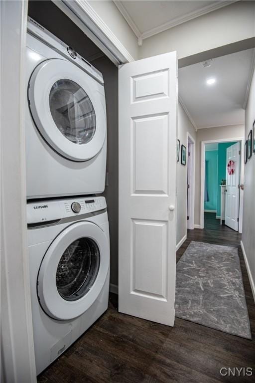 clothes washing area featuring dark hardwood / wood-style flooring, stacked washer / drying machine, and crown molding