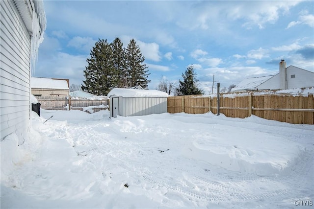 yard layered in snow with a storage shed