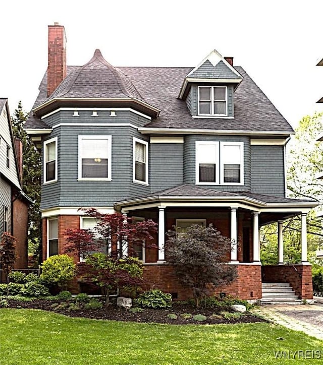 view of front of property featuring a front yard and covered porch