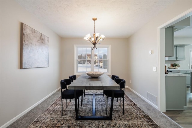 dining area featuring a textured ceiling and a notable chandelier