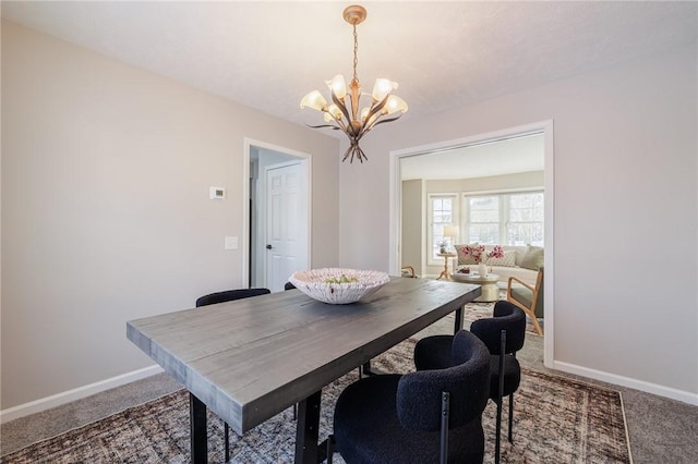 dining space with carpet flooring and a chandelier