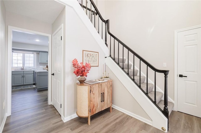 staircase with wood-type flooring and sink