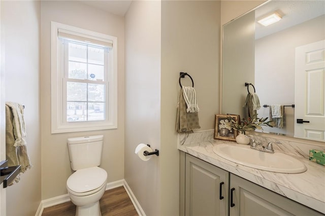 bathroom featuring wood-type flooring, vanity, and toilet