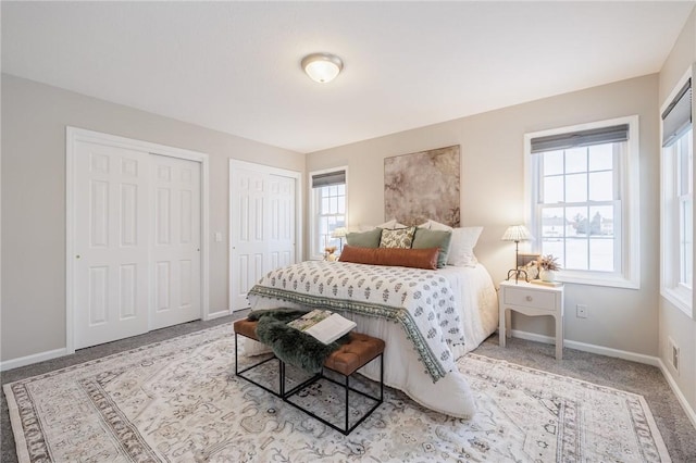 bedroom featuring multiple closets and light colored carpet