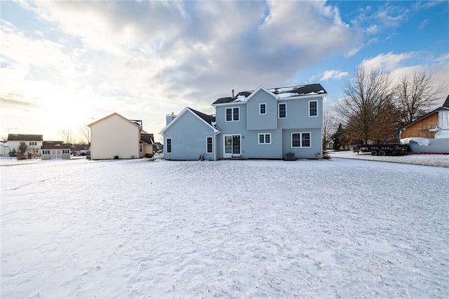 snow covered back of property featuring cooling unit