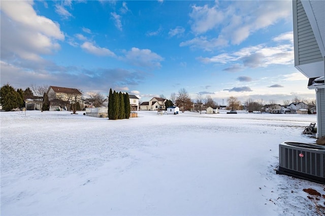 snowy yard featuring central AC