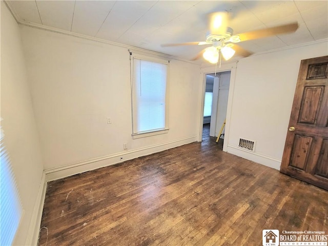 empty room with dark hardwood / wood-style flooring, ceiling fan, and crown molding