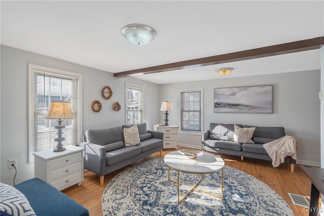 living room featuring light hardwood / wood-style floors and beamed ceiling