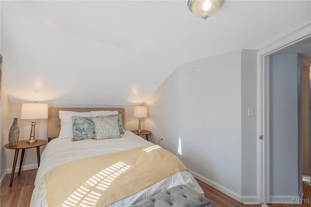 bedroom with lofted ceiling and hardwood / wood-style flooring