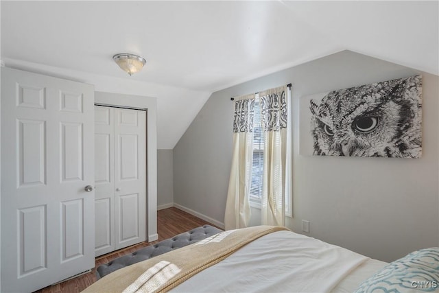 bedroom featuring lofted ceiling, a closet, and dark wood-type flooring