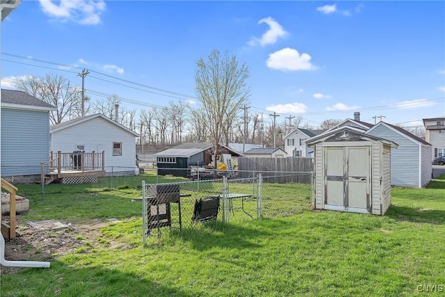 view of yard featuring an outdoor structure, a residential view, a shed, a deck, and fence