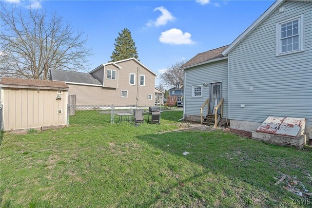 view of yard featuring fence, an outdoor structure, entry steps, and a shed