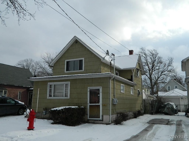 view of snow covered rear of property